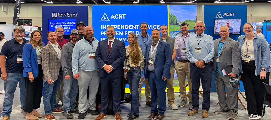ACRT Services team members pose at an exhibit booth with ACRT and EnviroScience displays at Trees & Utilities 2026.